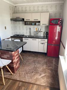 uma cozinha com um frigorífico vermelho e uma mesa em Departamento centro de Quellón em Quellón