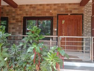 una puerta delantera de una casa con una planta en Hope villa homestay en Gokarna