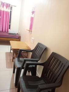Dos sillas negras y una mesa en una habitación en Hope villa homestay en Gokarna