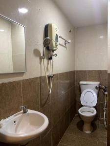 a bathroom with a white toilet and a sink at HOTEL SAHARA INN BATU CAVES in Batu Caves