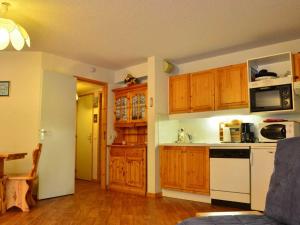 a kitchen with wooden cabinets and a white stove top oven at Charmant 2 pièces à Montchavin, près des pistes, pour 5 pers. - Balcons, équipements complets, parking - FR-1-329-1 in Bellentre +2 photos
