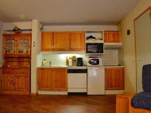 a kitchen with wooden cabinets and a white stove top oven at Charmant 2 pièces à Montchavin, près des pistes, pour 5 pers. - Balcons, équipements complets, parking - FR-1-329-1 in Bellentre