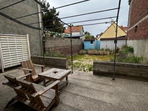 a patio with two wooden chairs and a table at Villa Quend, 4 pièces, 6 personnes - FR-1-730-8 in Quend
