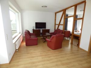 uma sala de estar com duas cadeiras e uma televisão em Grosse-Ferienwohnung-Wa2-100qm-im-Erdgeschoss-der-Villa-Walhall-in-einem-parkaehnlichen-Garten em Ostseebad Sellin
