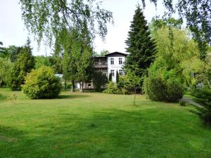 uma grande casa branca no meio de um quintal em Grosse-Ferienwohnung-Wa2-100qm-im-Erdgeschoss-der-Villa-Walhall-in-einem-parkaehnlichen-Garten em Ostseebad Sellin