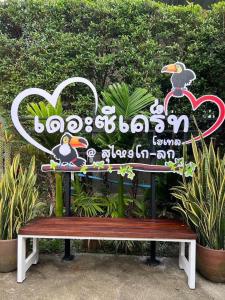 un banco sentado frente a un cartel en The Sekret Hotel en Sungai Kolok