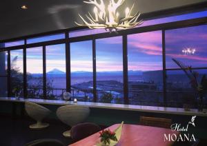 a dining room with a large window with a view at Hotel MOANA絶景オーシャンビューカフェラウンジ in Oshima