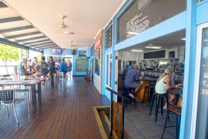 a group of people sitting at tables in a restaurant at Nightcap at Marine Hotel Cardwell in Cardwell