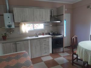 uma cozinha com um lavatório e um fogão forno superior em Puñadito de descanso em Salta
