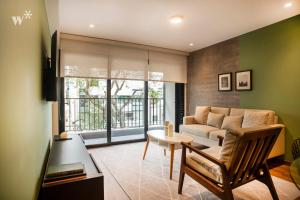 uma sala de estar com um sofá e uma mesa em Alcanfores by Wynwood House em Lima