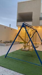 a swing set in front of a building at فلل شدا ورقان بالهدا in Al Hada