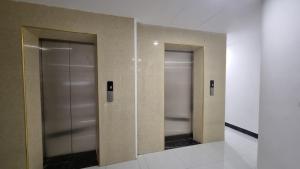 twee liften met hun deuren open in een gebouw bij Era Apartment Khuc Thua Du in Hanoi