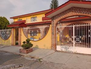 un edificio amarillo con una puerta delante en Finca girasoles en Ayala