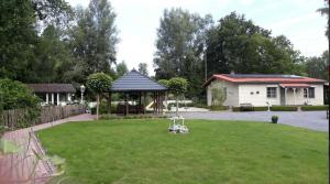 een tuin met een tuinhuisje en een huis bij Cosy-Cottage in Hechtel-Eksel