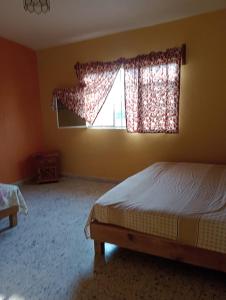 1 dormitorio con cama y ventana en Finca girasoles en Ayala
