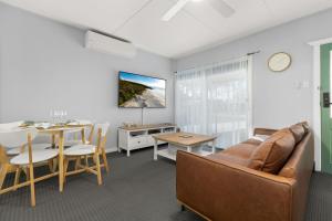 a living room with a couch and a table at Wanderer by Experience Jervis Bay in Sanctuary Point