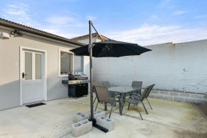 un patio avec une table et un parasol dans l'établissement Wanderer by Experience Jervis Bay, à Sanctuary Point