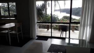 a living room with a large window looking out onto a deck at Pipiroa Bay Homestay in Russell