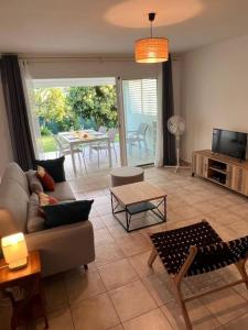 a living room with a couch and a tv and a table at Dans la douceur de Montebello in Petit-Bourg