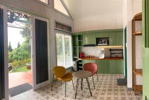 een keuken met groene kasten en 2 stoelen en een tafel bij Gracia Spa Resort Hotel in Ciater