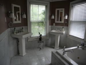 a bathroom with two sinks and a tub and two mirrors at Historic German Village Home/A+ Downtown Location in Columbus