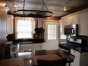 a kitchen with white cabinets and a black counter top at Historic German Village Home/A+ Downtown Location in Columbus