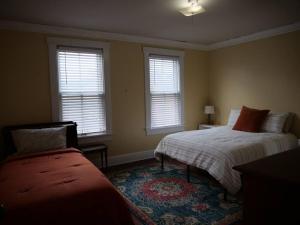 a bedroom with two beds and two windows at Historic German Village Home/A+ Downtown Location in Columbus