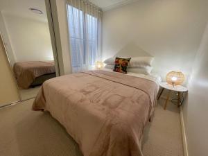 een slaapkamer met een groot bed en een spiegel bij Andy & Anna's Weekend Hideaway in Newcastle