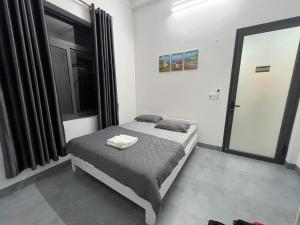 1 dormitorio con cama y ventana grande en Tammy homestay- Ganh Da Dia, en Tuy An