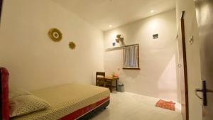 a small bedroom with a bed and a table at Nitha Homestay in Banyuwangi