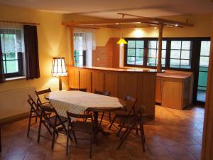 a dining room with a table and chairs and a kitchen at Hajduk Apartment in Międzylesie