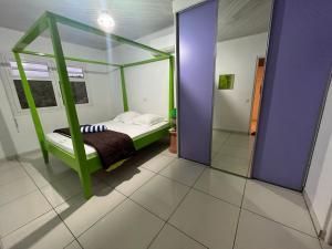 ein Schlafzimmer mit einem Bett mit einem grünen Rahmen in der Unterkunft Le PatBle au Makaré Lagoon Club in Le Vauclin