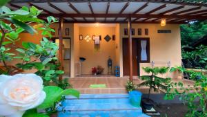 a house with a staircase leading to the front door at Nitha Homestay in Banyuwangi