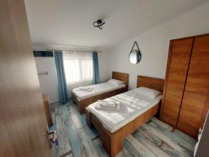 una piccola camera con due letti e una finestra di SeaHorse GuestHouse a Năvodari