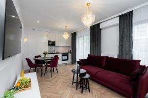 ein Wohnzimmer mit einem roten Sofa und einem Tisch in der Unterkunft Exclusive Crystal Apartment in Krakau