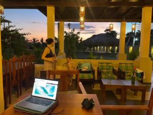 阿魯岡灣的住宿－Paddyway Resort，坐在餐厅里的女人,桌上有笔记本电脑