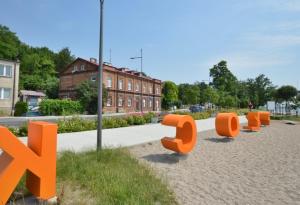 una fila de orangeulpturas en un parque con un edificio en Apartament nad Wisłą, en Płock