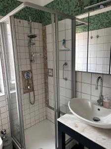ein Bad mit einer Dusche und einem Waschbecken in der Unterkunft Huus Mövchen in Borkum