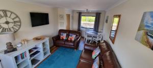 a living room with a couch and a table at Benview House in Corpach