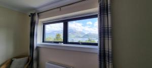 a window in a room with a view of a mountain at Benview House in Corpach