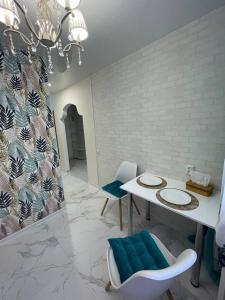 ein Esszimmer mit einem weißen Tisch und blauen Stühlen in der Unterkunft White Apartment Світло є завжди in Dnipro