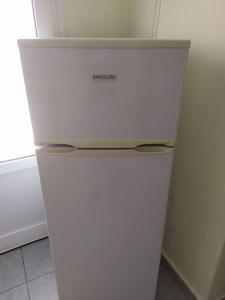 a white refrigerator in a room with a window at Big family house (detached) in Néa Péramos