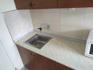 a kitchen sink with a faucet on a counter at Big family house (detached) in Néa Péramos