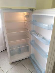 an empty refrigerator with its door open in a kitchen at Big family house (detached) in Néa Péramos