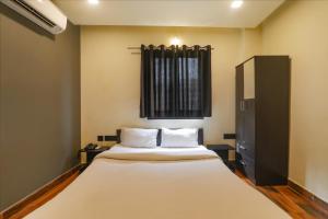 a bedroom with a large bed and a window at FabHotel Lemon Grass - Assi Ghat in Varanasi