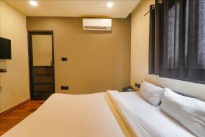 a bedroom with a white bed and a window at FabHotel Lemon Grass - Assi Ghat in Varanasi
