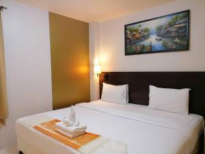 una camera da letto con un grande letto bianco con una foto appesa al muro di Amici Miei Guest House a Patong Beach