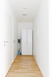 ein leeres Zimmer mit weißen Türen und Holzboden in der Unterkunft Whats-App Self-Check-IN - 1BR Apartment, near airport,15 min to Center in Wien + 18 Fotos
