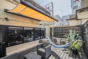 静岡市にあるビル泊 -Birupaku Decentralized Hotel-の建物のバルコニーにハンモック