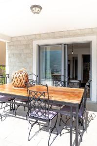 ein Holztisch und Stühle auf einer Terrasse in der Unterkunft Apartments Castello Risano in Risan
